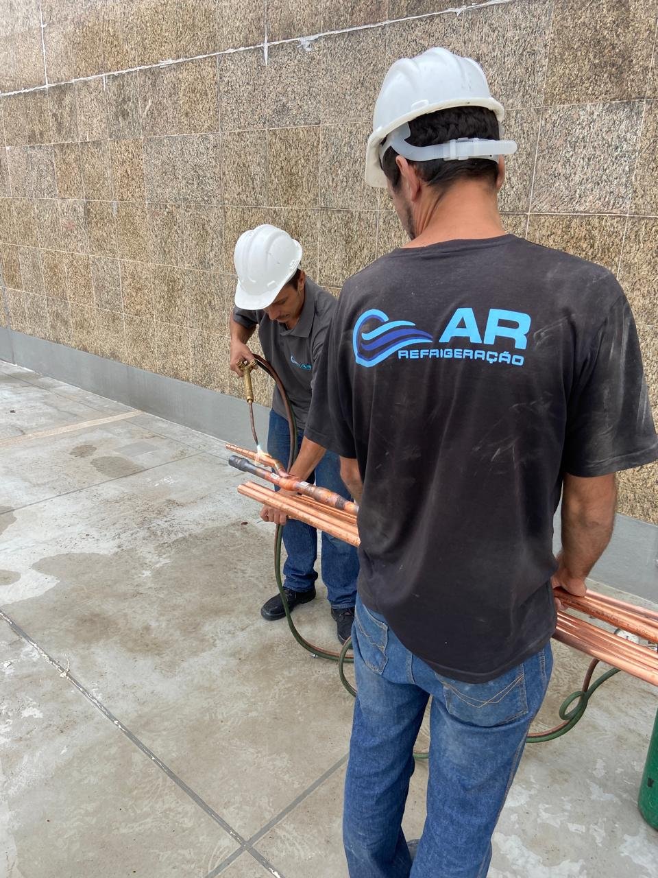 Equipe da Ar Refrigeração em manutenção de ar condicionado